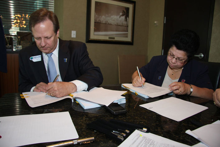 Jack Levine and Maria Brackett sign merger documents